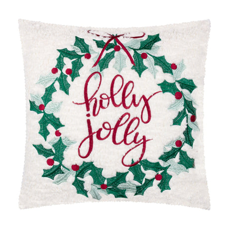 Square white bouclé cushion embroidered with a green holly wreath, red berries, a red bow, and "holly jolly" script, shown on a plain background.