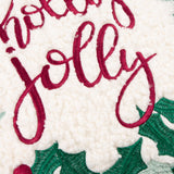 Close-up of the Holly Wreath Bow Velvet Cushion showing "Holly Jolly" embroidered in red script on textured white bouclé, framed by green holly leaves.