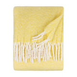 Isla Plain Polyester Throw in butter yellow, folded to show a woven cream-flecked texture and white tasselled fringe, on a plain white background.