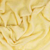Isla Plain Polyester Throw in butter yellow, softly draped to show its woven texture with fine cream flecks creating a subtle two-tone effect.