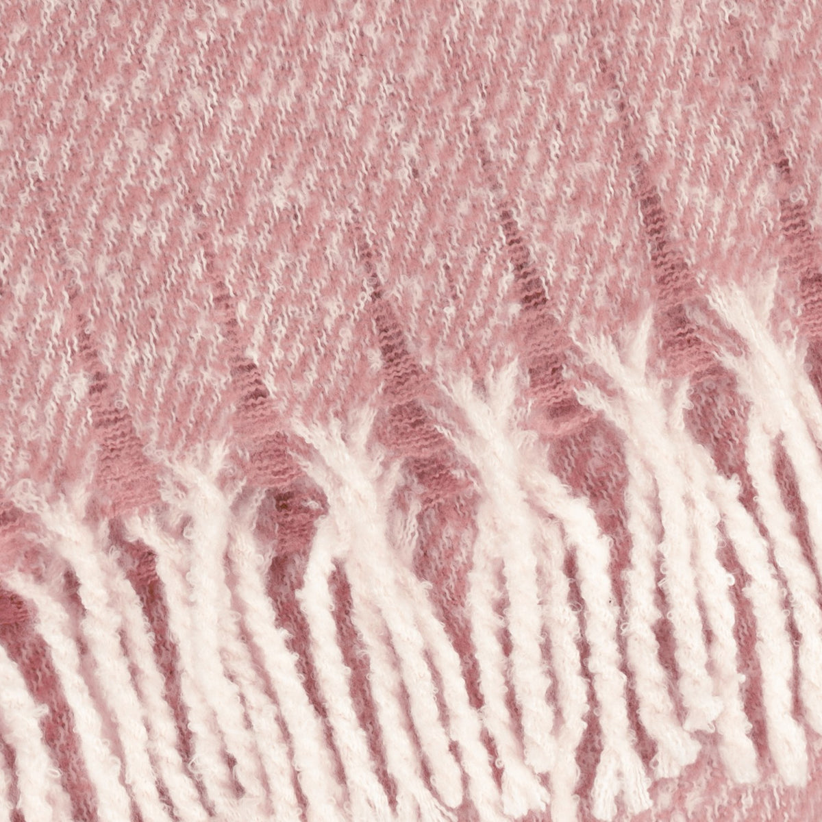 Close-up of the Isla Plain Polyester Throw in heather pink, showing the twill weave with pale flecks and a soft tasselled fringe trim.