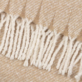 Close-up of the Isla Plain Polyester Throw in natural beige, showing its diagonal weave with cream flecks and knotted tassel fringe trim.