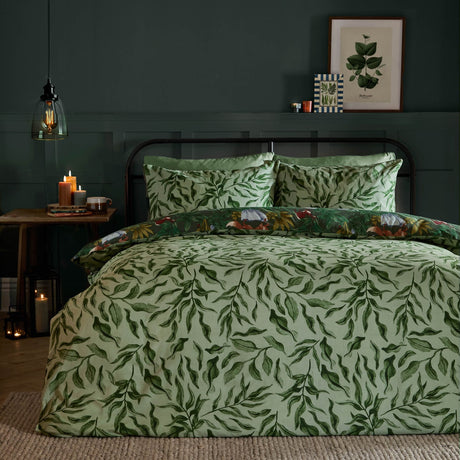 Into The Woods reversible duvet cover set on a bed, sage green painterly leaf side shown, with matching pillowcases in a dark green panelled bedroom.