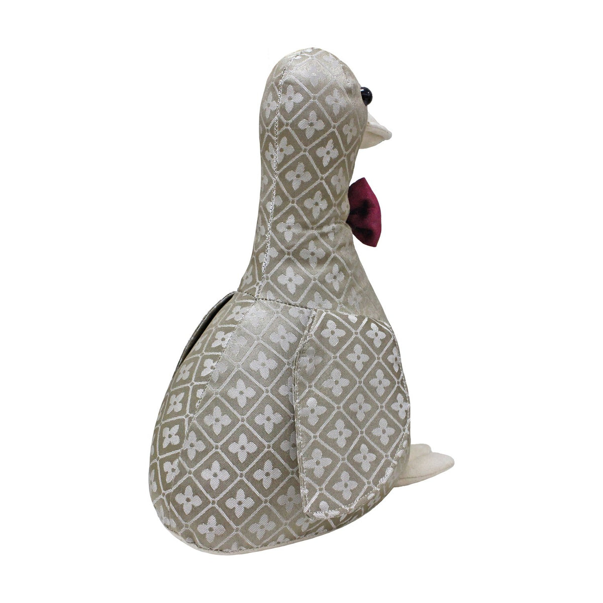 Duck-shaped door stop in grey and off-white jacquard floral diamond pattern, with cream beak and feet, red bow tie, black bead eyes, on a plain white background.
