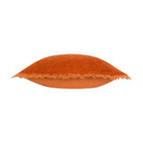 Jaye Velvet Cotton Cushion in rust orange, shown side-on with fringed edge trim and plain cotton reverse, set against a white background.