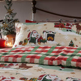 Jolly Santa Printed Gingham Duvet Cover Set in Multi, showing a cream pillowcase and duvet with Santa, reindeer and festive scenes, paired with a red and green check reverse, styled on a bed.