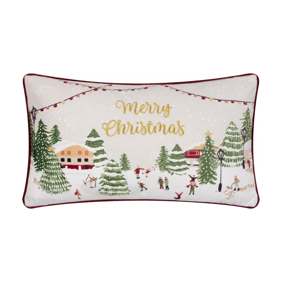 Cream rectangular cushion embroidered with a snowy village scene, festive trees and figures, gold Merry Christmas text, and a berry red piped edge.