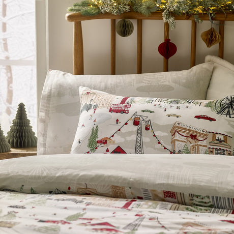 Reversible Joy To All duvet cover set with matching pillowcase, featuring a cream, red and green festive cityscape design with buses, cable cars and skaters.