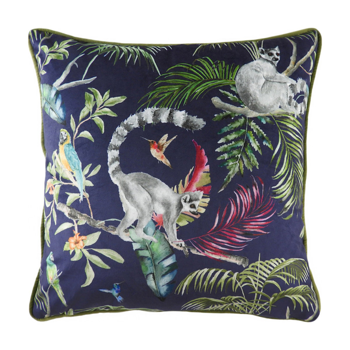 Square velvet-feel cushion in navy blue with a hand-painted jungle scene of ring-tailed lemurs, parrots, a hummingbird and tropical fronds, finished with green piped trim, shown on a white background.