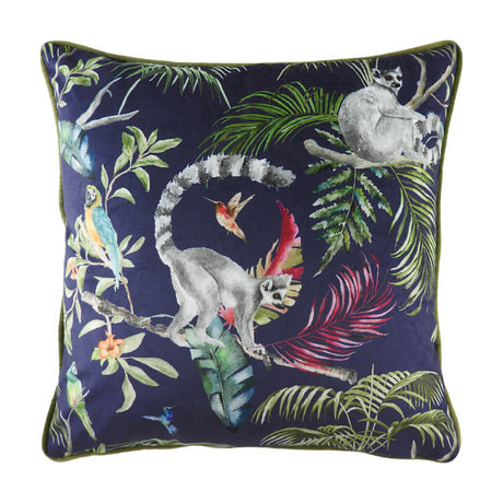 Square velvet-feel cushion in navy blue with a hand-painted jungle scene of ring-tailed lemurs, parrots, a hummingbird and tropical fronds, finished with green piped trim, shown on a white background.