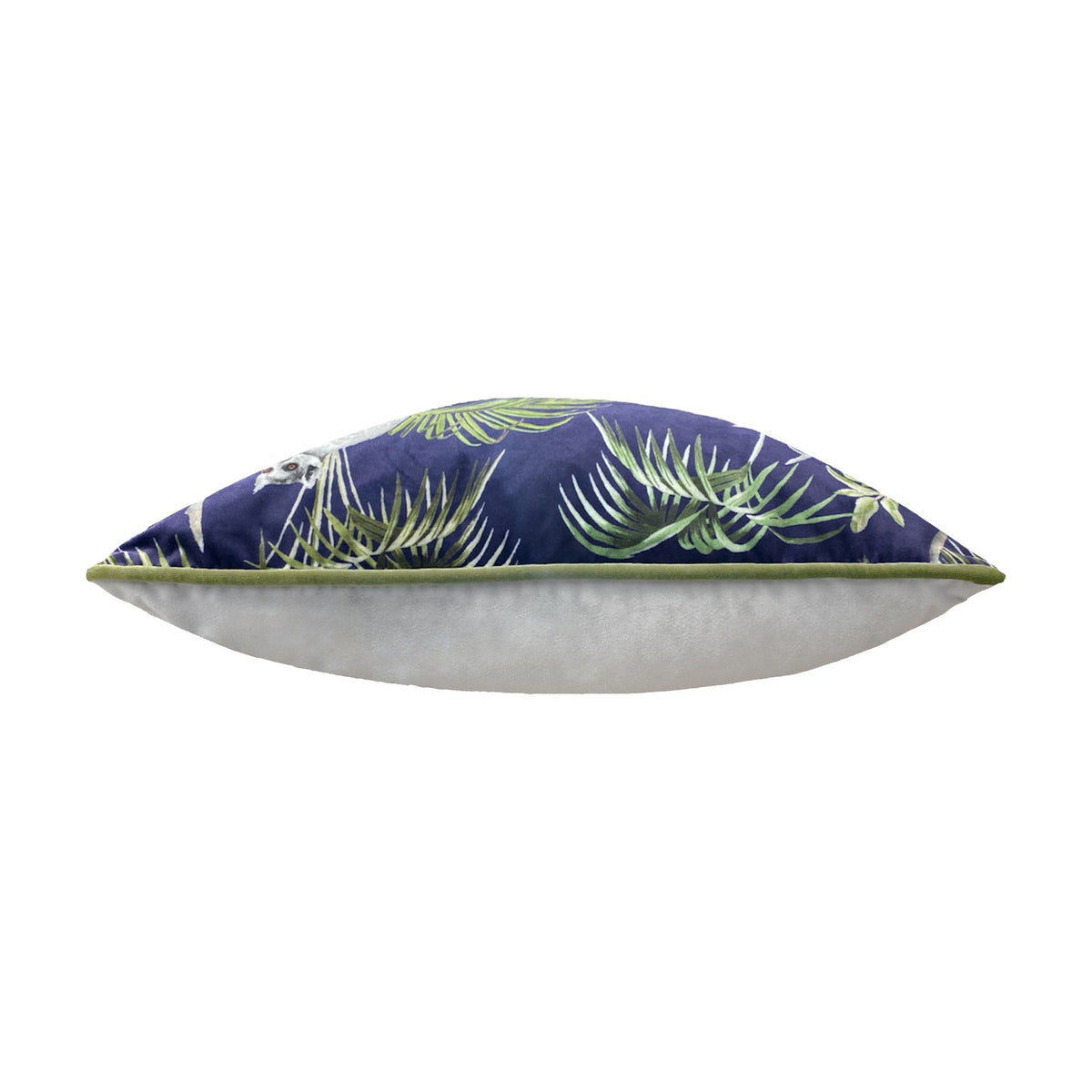 Side view of the Jungle Animal Velvet Cushion in blue, showing its plump velvet-feel edge with green piped trim and tropical leaf print, set against a plain white background.