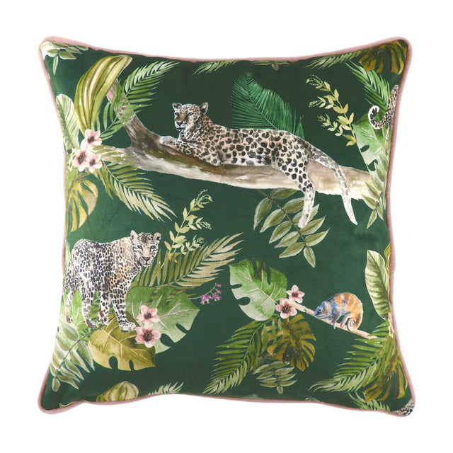 Square green velvet cushion with a jungle print of two leopards, tropical leaves, pink blossoms and a chameleon, finished with pink piping on a white background.
