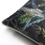 Square velvet cushion, corner view, with a hand-painted jungle scene of a leopard among palm leaves and ferns on a dark ground, edged with petrol-green piping.