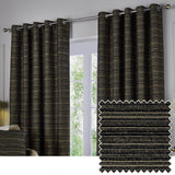 Jupiter Chenille eyelet curtains in black and gold hung on a chrome pole beside a window, with a fabric swatch showing the fine striped weave.