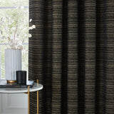 Jupiter Chenille Fully Lined Eyelet Curtains in Black/Gold, showing fine gold pearlescent stripes on a black chenille jacquard fabric, styled in a living room with a marble side table and vase.