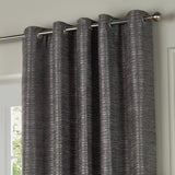 Jupiter Chenille Fully Lined Eyelet Curtains in graphite, showing the eyelet header on a chrome pole with textured fabric hanging in a living room setting.