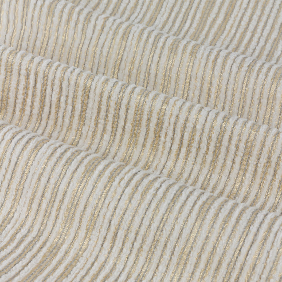 Close-up of Jupiter Chenille Fully Lined Eyelet Curtains in ivory and gold, showing fine horizontal woven texture with subtle metallic threading across draped folds.
