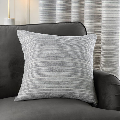 Jupiter Jacquard Chenille Cushion in silver grey with a fine horizontal striped weave, styled on a dark grey sofa against striped curtains.