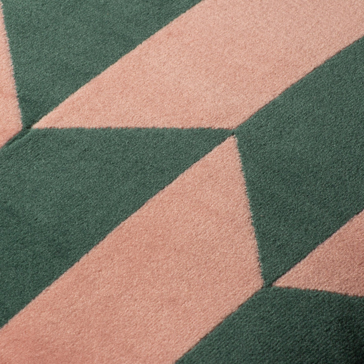 Close-up of the Kalho Jacquard Velvet Cushion in pink and green, showing the woven geometric triangle pattern and textured velvet pile in detail.