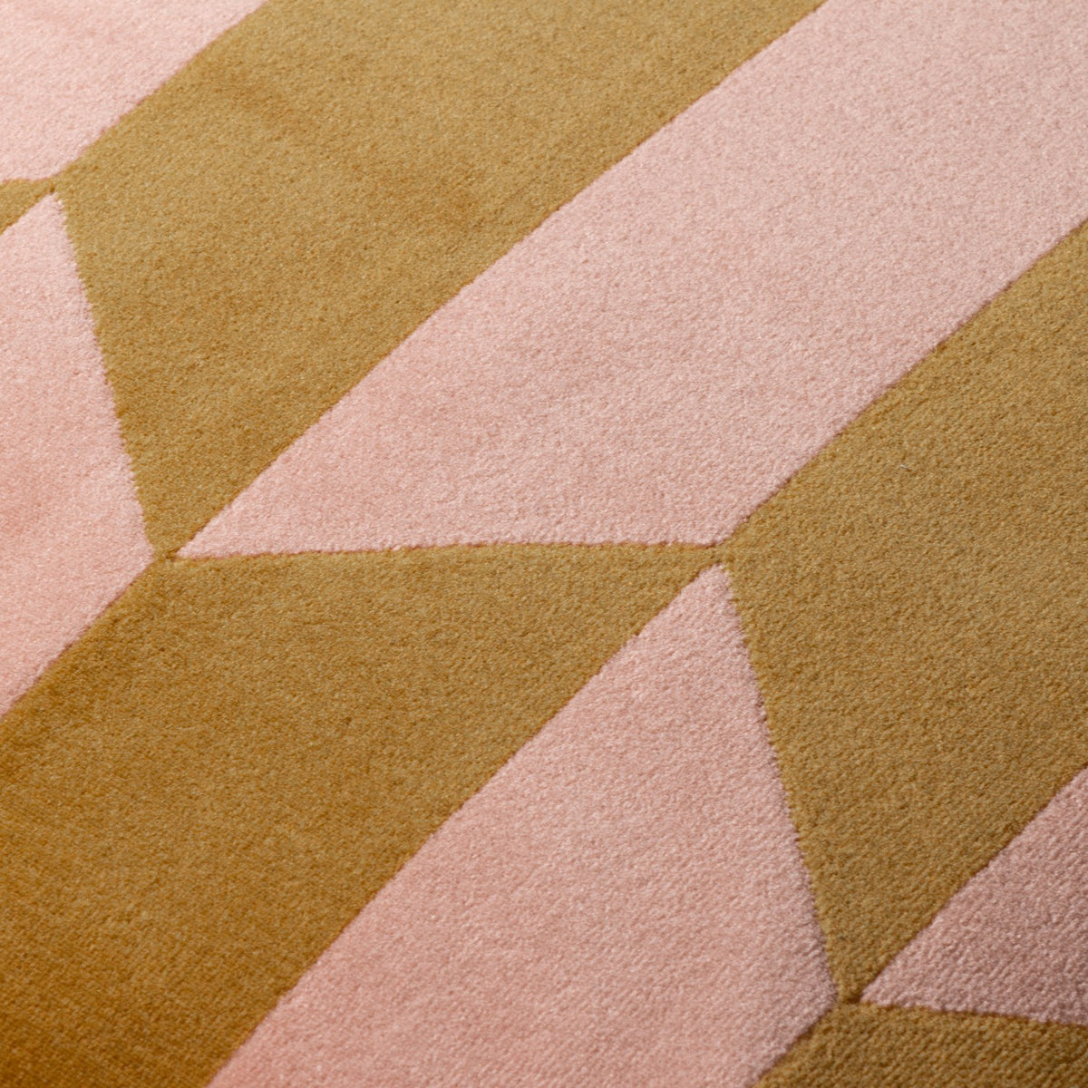 Close-up of the Kalho Jacquard Velvet Cushion in pink and ochre, showing the woven geometric pattern with tapering triangular blocks and a matt, brushed velvet texture.