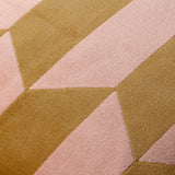 Close-up of the Kalho Jacquard Velvet Cushion in pink and ochre, showing the woven geometric pattern with tapering triangular blocks and a matt, brushed velvet texture.