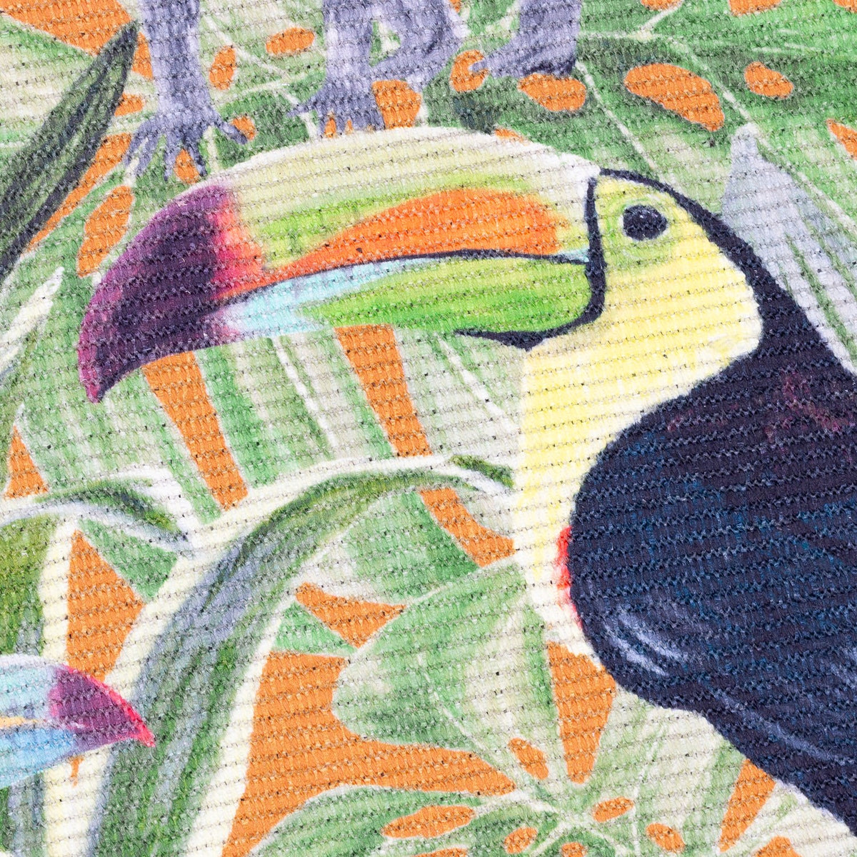 Close-up of the Kali Animals Abstract polyester rug showing a toucan's head and beak amid green palm fronds on an orange background.