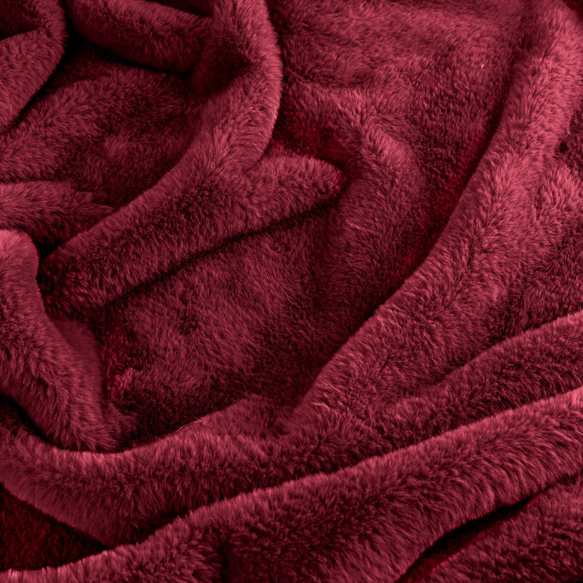 Kallu Polyester Throw in Berry, a deep red faux fur throw with dense, plush pile shown in close-up folds and ripples.