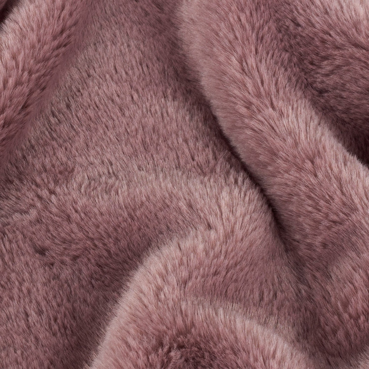 Close-up of the Kallu Reversible Faux Fur Throw in mulberry, showing dense, plush pile fabric with soft folds in a muted pink-brown tone.