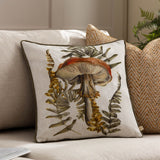 Kielder Forest Mushroom Velvet Cushion in Natural, cream fabric front with hand-painted rust mushroom and olive fern design, shown on a beige sofa.