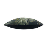 Side view of the Kibale Jungle polyester cushion, showing a tropical leaf print in green and rust tones on one face and plain black on the reverse, set on a white background.