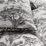 Kisumu Cotton Jungle Duvet Cover Set in monochrome, showing a pillowcase with hand-drawn Baobab tree and monkey toile print, edged with leopard-print piping.