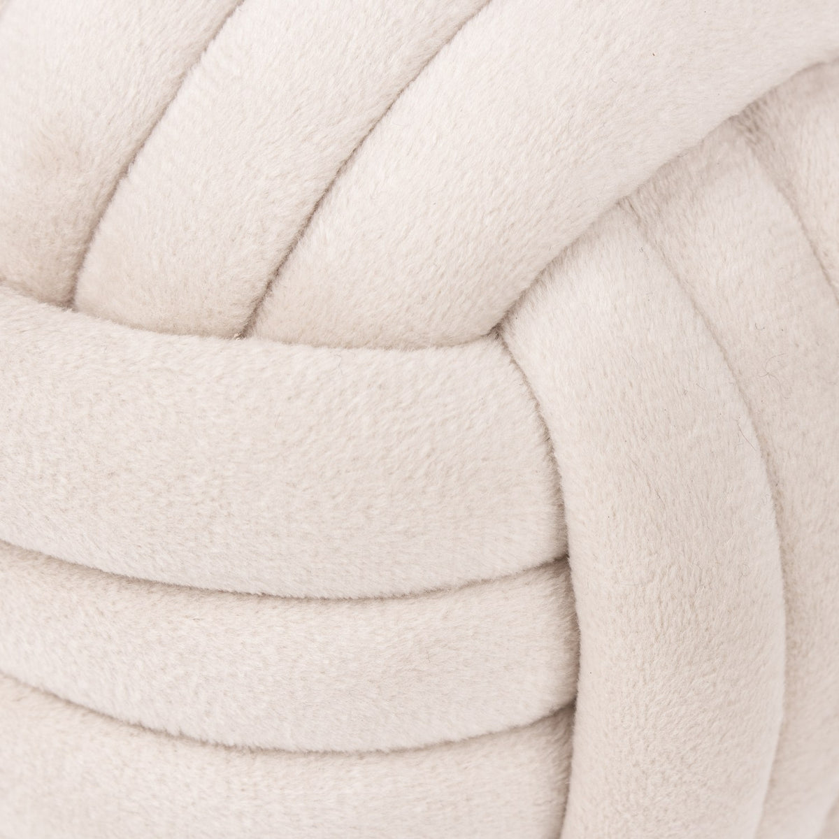 Close-up of the Knot Plain Velvet Door Stop in natural off-white, showing the interlaced knotted bands of soft plush velvet fabric.