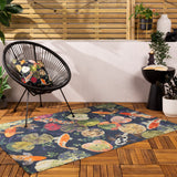 Koi Pond Animal Polyester Rug in Midnight, a navy flatweave rug with orange and white koi carp and lily pads, shown on a wooden deck beside a black woven chair.