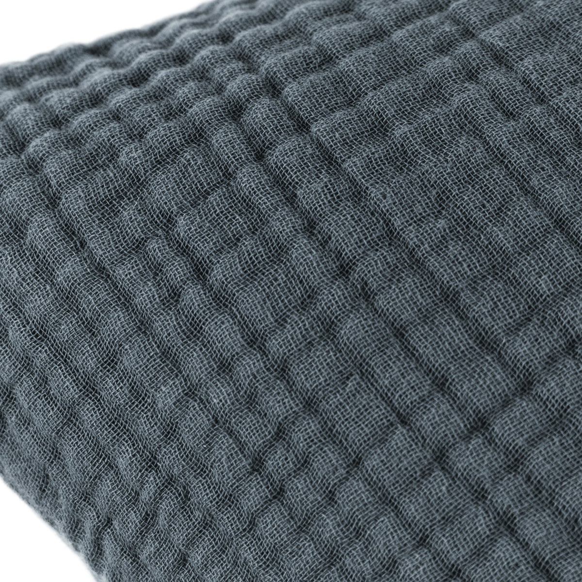 Close-up of the Lark Reversible Cotton Cushion in Dusk, showing the four-layer muslin crinkle cotton's ribbed, waffle-textured surface in muted blue-grey.