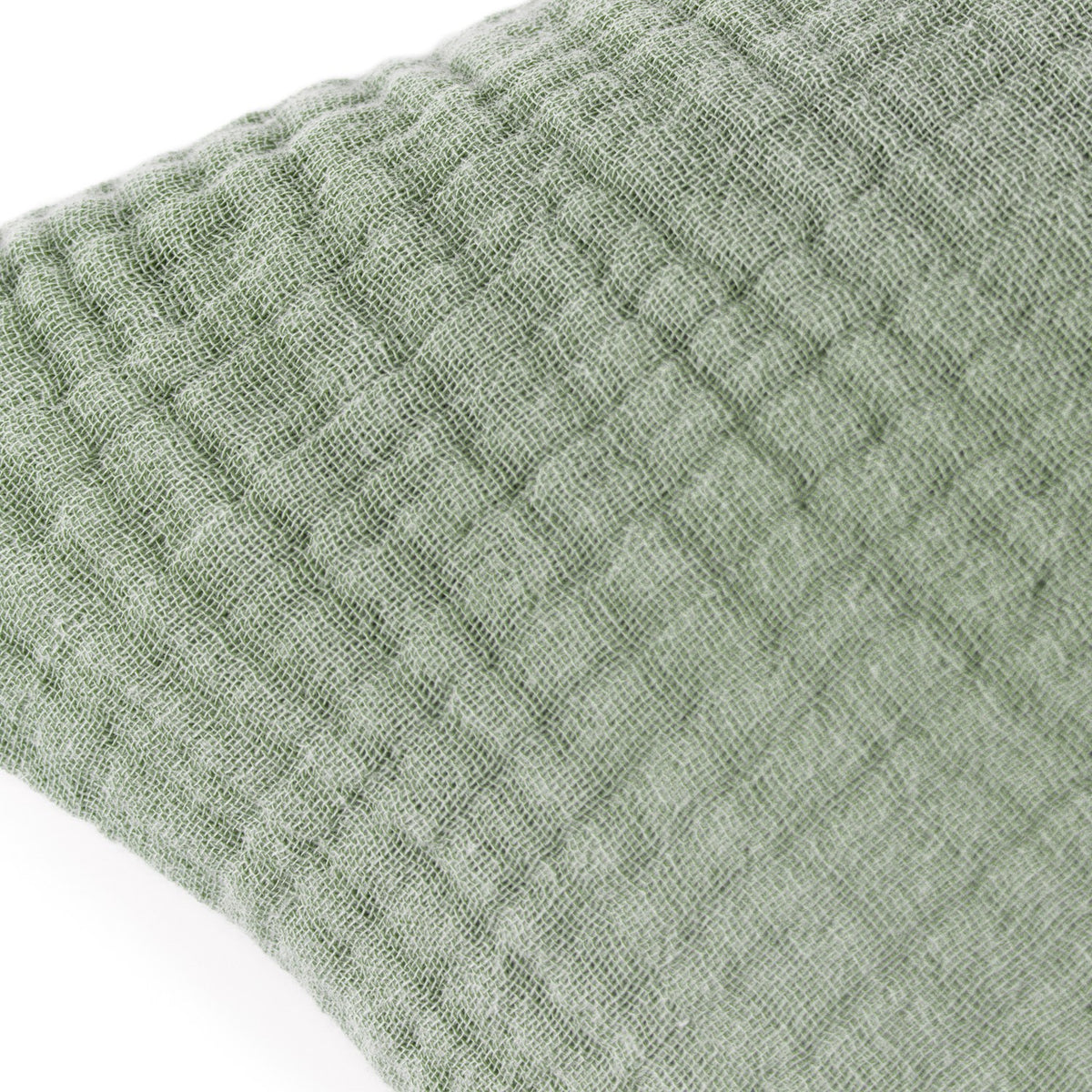 Close-up of the Lark Reversible Cotton Cushion in eucalyptus green, showing the crinkled four-layer muslin cotton texture and subtle woven ribbing.