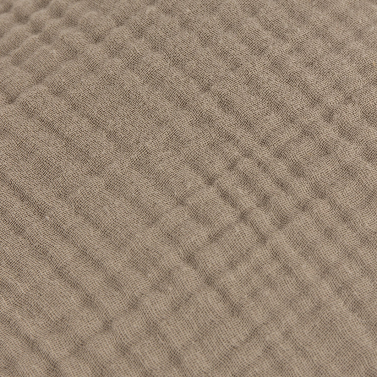 Close-up of the Lark Plain Cotton Cushion in mole brown, showing the crinkled four-layer muslin cotton texture with fine rippled lines.