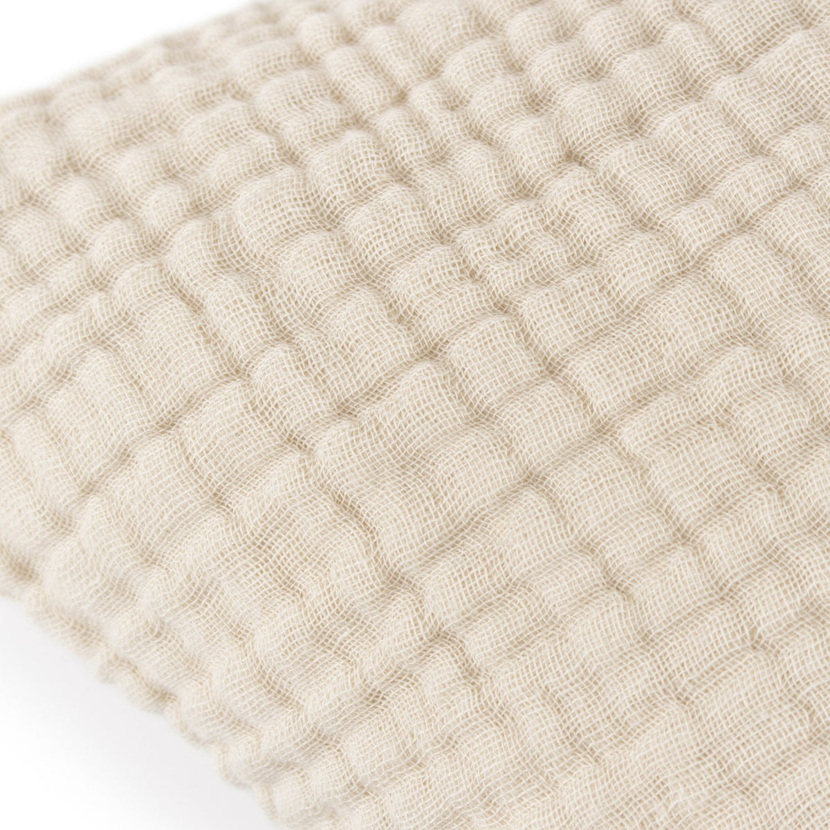 Close-up of the Lark Reversible Cotton Cushion in natural beige, showing four-layer muslin crinkle cotton with a ribbed, textured surface.