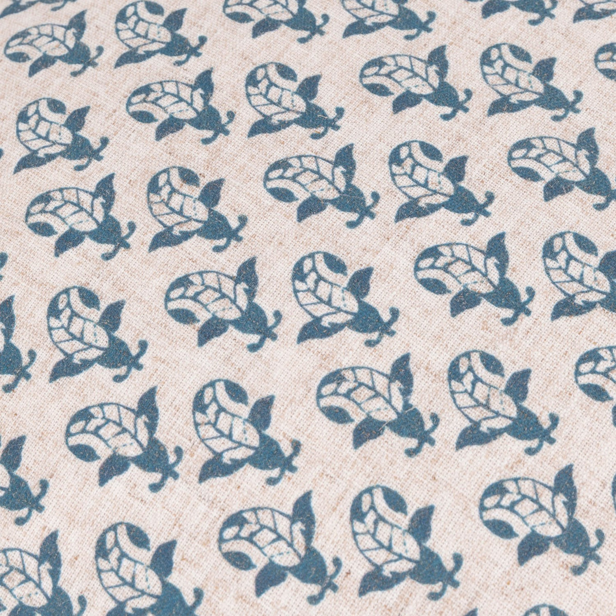 Lulah Block Floral Linen Cushion in blue, close-up of the repeating leaf-and-bud print on natural oatmeal linen-blend fabric.