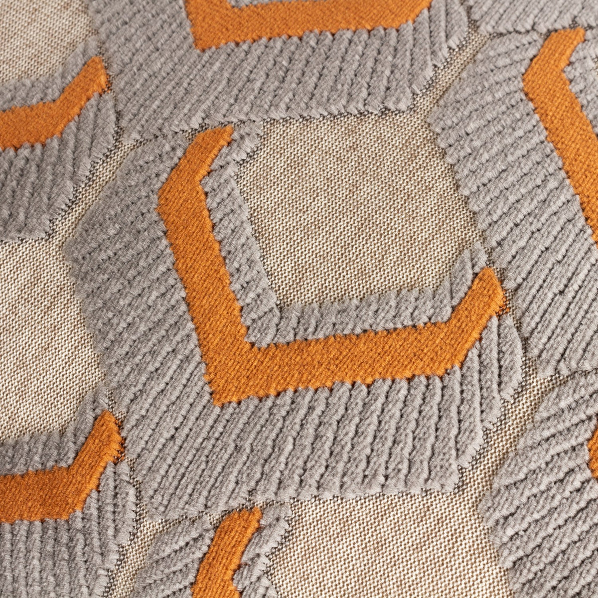Close-up of the Ledbury Jacquard Velvet Cushion in Ginger/Grey, showing raised chevron-topped hexagon velvet pattern against a flatter woven ground.