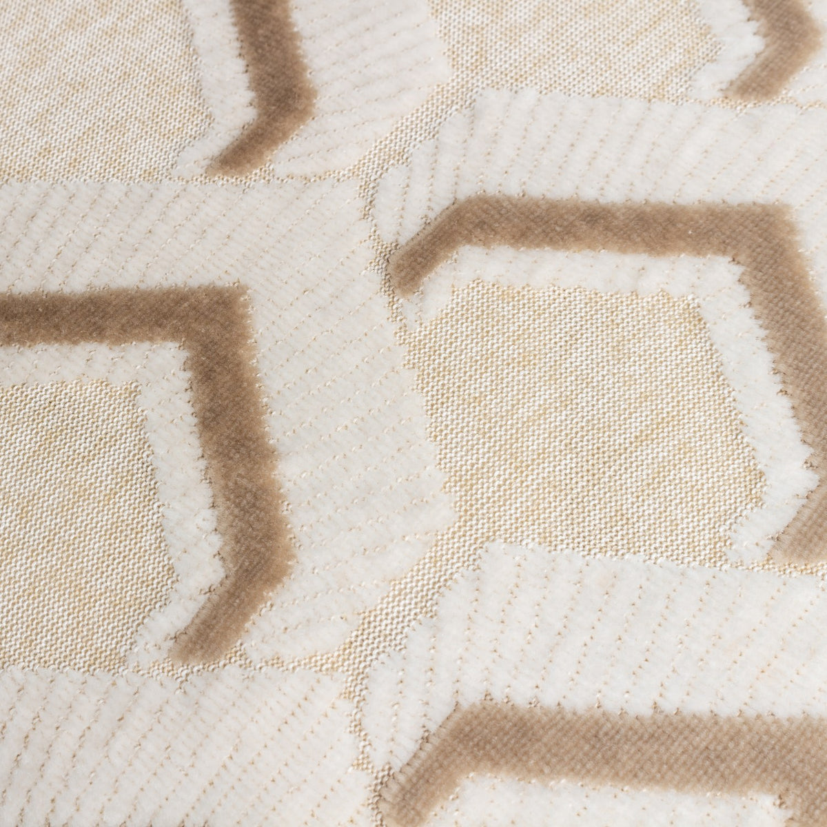 Close-up of the Ledbury Jacquard Velvet Cushion in warm taupe, showing a raised hexagonal pattern in soft pile against a cream jersey-look ground.