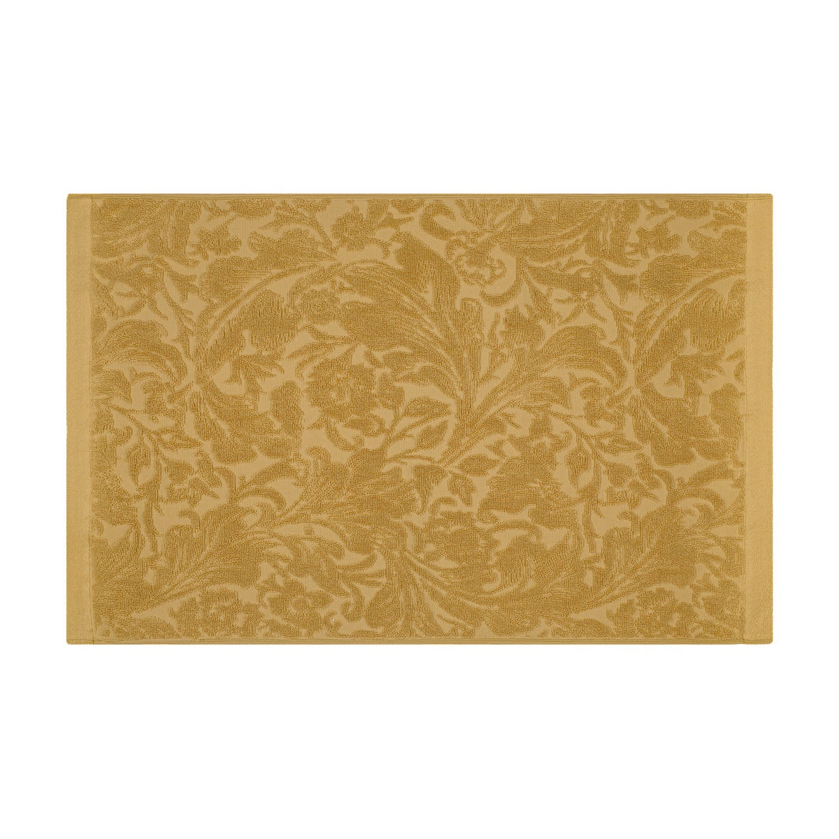 Leicester Floral Cotton Bath Mat in gold, rectangular with a woven scrolling floral pattern edge to edge and plain borders on the shorter sides, shown on a white background.