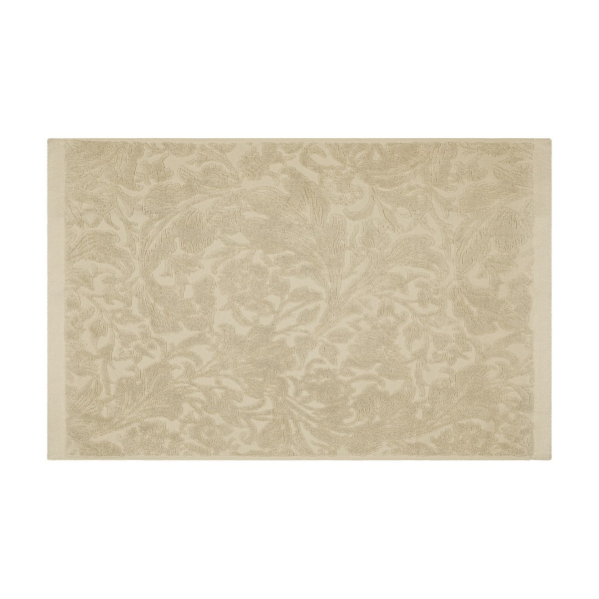 Leicester Floral Cotton Bath Mat in natural, rectangular with woven tone-on-tone scrollwork pattern and plain border edging, shown on a plain white background.