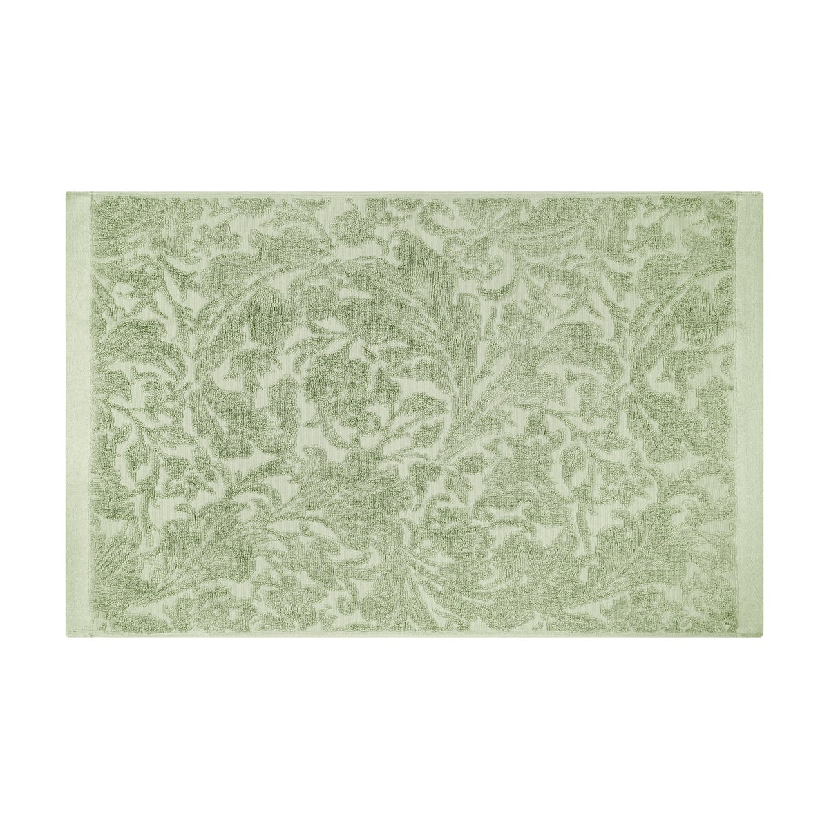 Leicester Floral Cotton Bath Mat in sage green with a raised scrolling acanthus leaf pattern and plain woven side borders, shown on a white background.