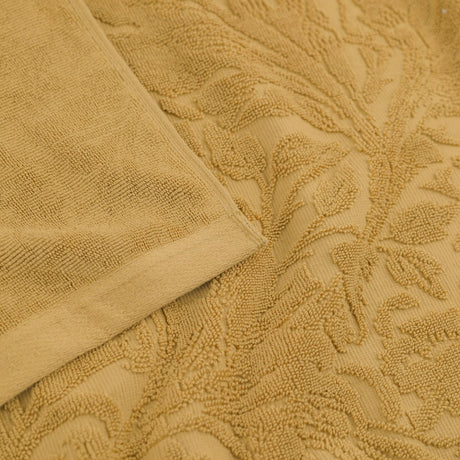 Leicester Floral Cotton Towels in gold, close-up of the folded edge and sculpted heritage foliage pattern in soft honey-toned pure cotton pile.