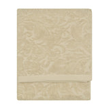Leicester Floral Cotton Towel in natural, folded flat with a raised scrolling leaf and floral pattern woven into the pile, shown against a plain white background.