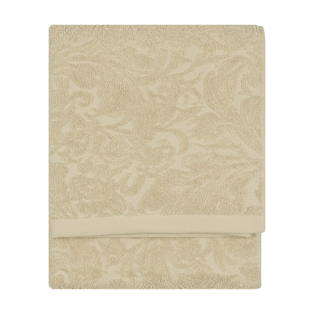 Leicester Floral Cotton Towel in natural, folded flat with a raised scrolling leaf and floral pattern woven into the pile, shown against a plain white background.
