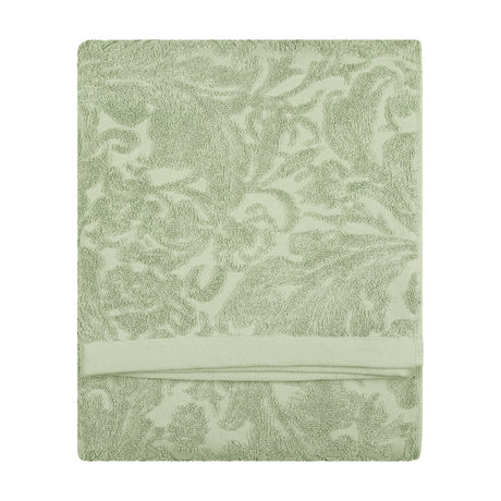Folded Leicester cotton towel in sage green with a woven floral and foliage jacquard pattern and plain woven border band, shown on a white background.