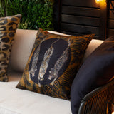 Leopardis reversible polyester cushion, 50x50cm, black and gold, showing three leopards in a dark medallion framed by amber palm fronds, styled on a sofa with a leopard-print cushion.