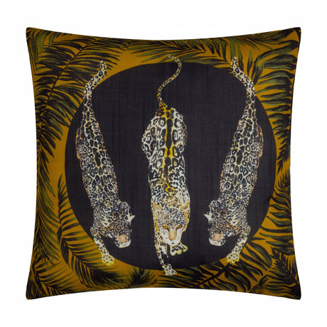 Square Leopardis polyester cushion in black and gold, printed with three leopards in a dark circular medallion framed by amber and green palm fronds, shown on a white background.