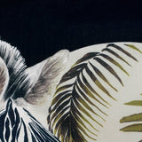 Leopardis reversible polyester cushion close-up showing a zebra head with olive and cream palm frond print on a black ground.